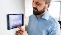Mann steuert Geräte mit Smart Home