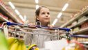 Mädchen mit Einkaufswagen im Supermarkt