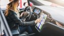 Frau navigiert auf Touchscreen ihres Autos