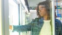 Frau wählt gekühlte Lebensmittel im Supermarkt aus Kühlregal aus