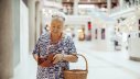Ältere Frau mit Geldbeutel und Einkaufskorb 