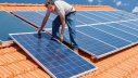Eigenheimbesitzer bei der Installation von Solarpanelen auf dem Dach