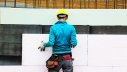 Bauarbeiter bringt Wärmedämmplatten an einer Fassaden an