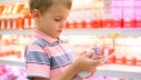 Junge im Supermarkt sich ein Produkt in seinen Händen anschauend