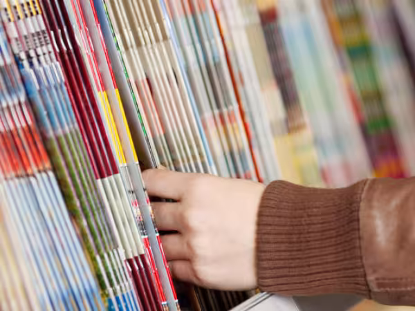 Mann stöbert in Magazinauslage 