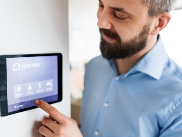 Mann steuert Geräte mit Smart Home