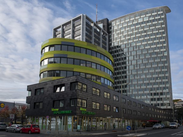 Zu sehen ist ein vierteiliges Gebäudeensemble bestehend aus einer 22-geschossigen Hochhausscheibe, einem dreigeschossigen Flachbau, einem elliptischen dreigeschossigen Turm, der Pillbox, sowie einer geschwungenen Konvektionsfassade, der früheren GSW-Hauptverwaltung. In dem Flachbau und der Pillbox befinden sich die Büroräume des vzbv. 