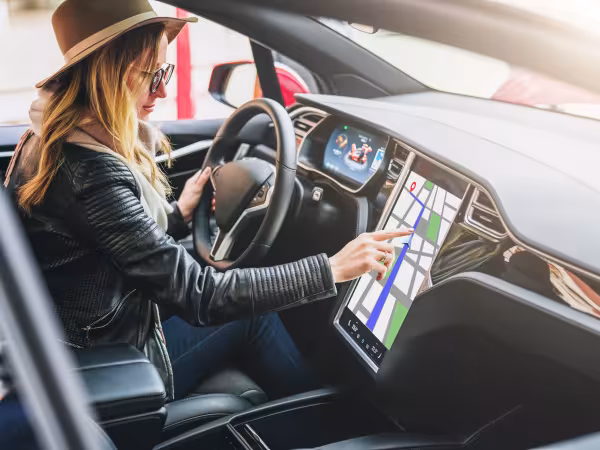Frau navigiert auf Touchscreen ihres Autos