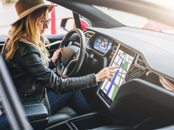 Frau navigiert auf Touchscreen ihres Autos