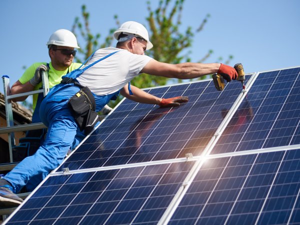 zwei Arbeiter montieren Photovoltaikanlage