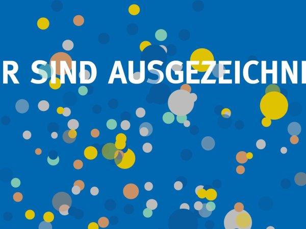 Schriftzug "Wir sind ausgezeichnet" mit Konfetti im Hintergrund