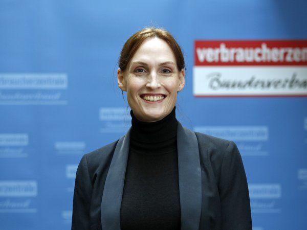 Zu sehen ist Jutta Gurkmann im Portrait vor einer blauen vzbv-Wand mit vzbv Logo.