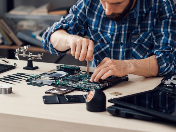 Mann repariert technische Geräte