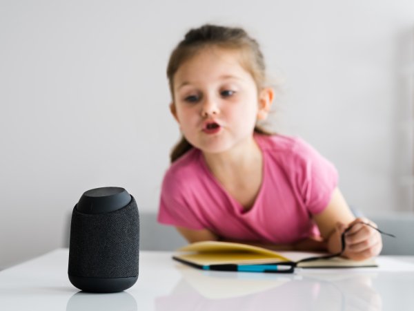 Kind benutzt Smart Speaker Anlage