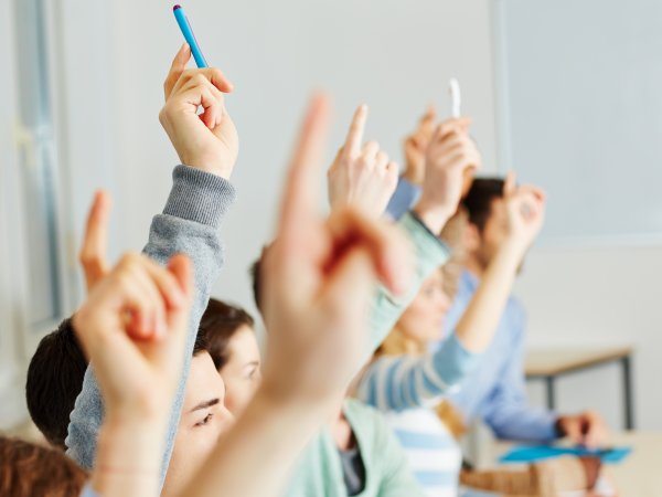 Schüler und Schülerinnen heben die Hand