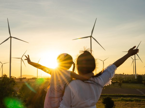 Menschen, die vor Windräder stehen