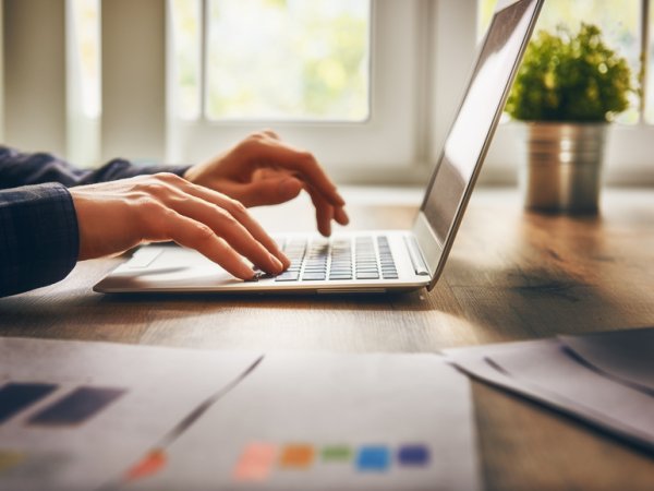 Mensch, der auf Laptoptasten drückt