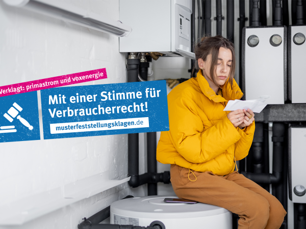 Frau sitzt in Heizungsraum und liest Stromrechnung