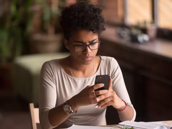 Frau schaut skeptisch auf ihr Smartphone