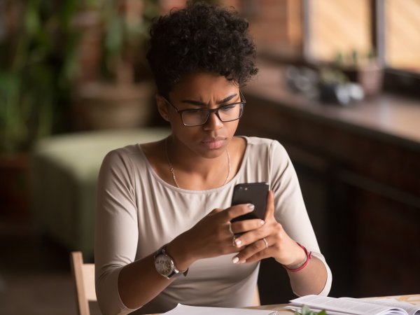 Frau schaut skeptisch auf ihr Smartphone