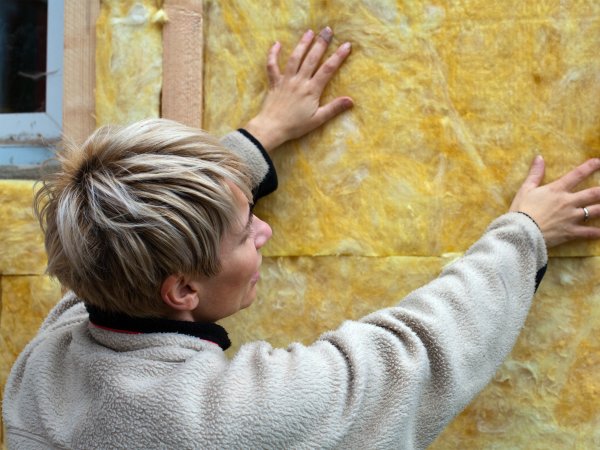 Frau dämmt Hauswand