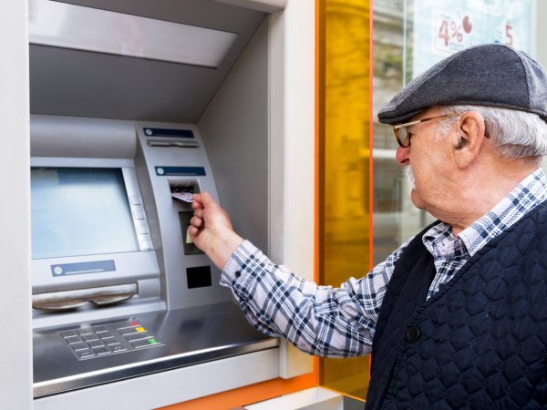 Mann hebt Geld vom Geldautomaten ab 