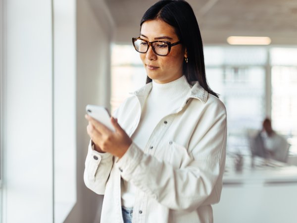 Junge Frau schaut auf ihr Handy