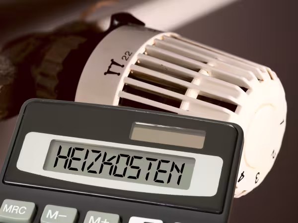 Heizung mit Taschenrechner davor mit der Aufschrift "Heizkosten"