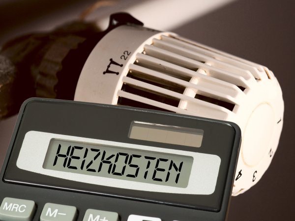 Heizung mit Taschenrechner davor mit der Aufschrift "Heizkosten"