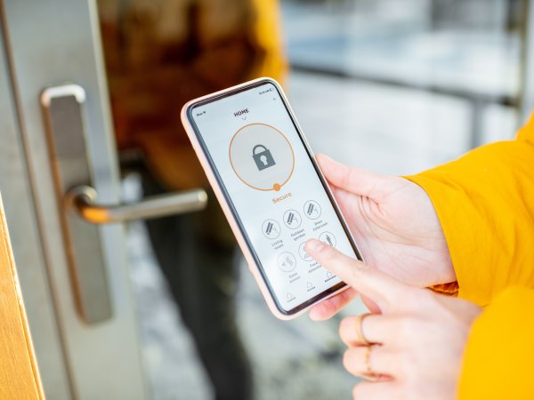 Verbraucherin öffnet per Handy das digitale Türschloss
