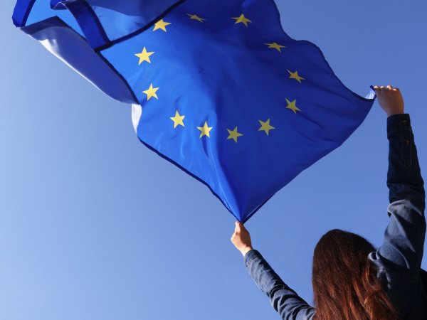 Person hält eine EU-Flagge in den Himmel