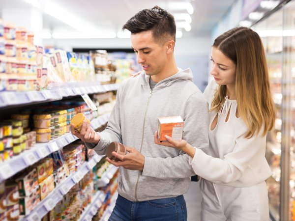 Pärchen im Supermarkt vergleicht verschiedene Artikel
