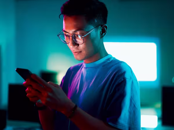 Junger Mann schaut auf sein Smartphone