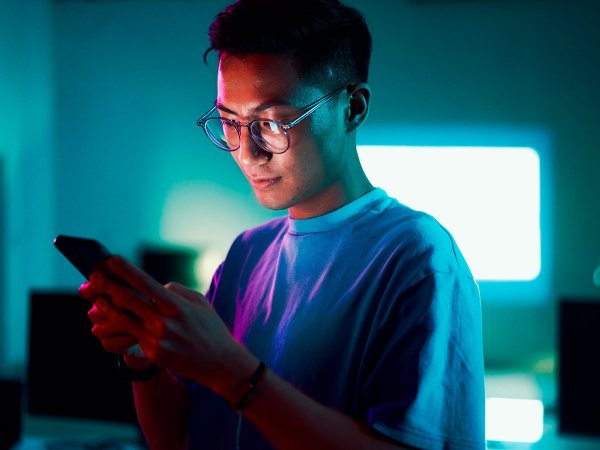 Junger Mann schaut auf sein Smartphone