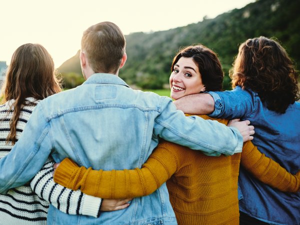 Gruppe von Menschen steht zusammen, eine Frau dreht sich zur Kamera um