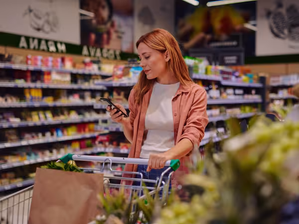 Frau im Supermarkt begutachtet Ware