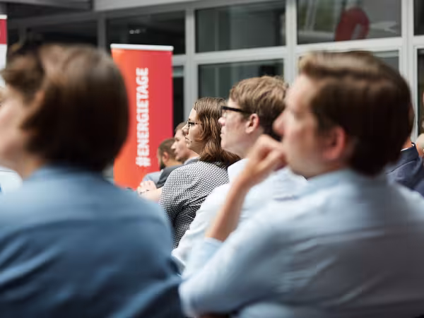 verschwommenes Bild von Publikum mit scharfen Banner der Energietage im Hintergrund