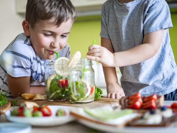 Kinder am Tisch mit frischem Obst