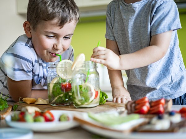 Kinder am Tisch mit frischem Obst