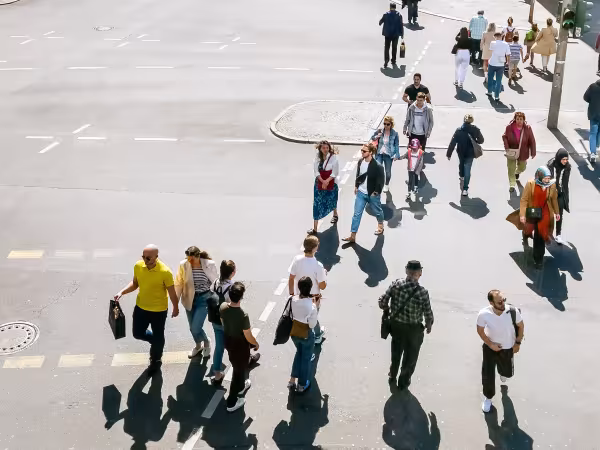 Viele Menschen laufen über eine Kreuzung in der Stadt