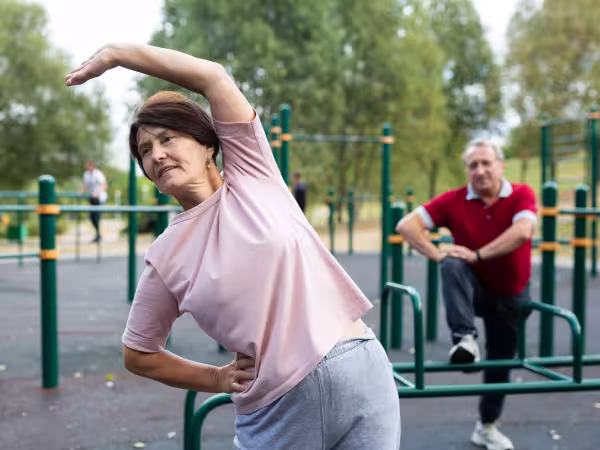 Zwei Personen machen Fitnessübungen in einem öffentlichen Fitnesspark.