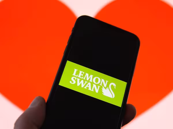 Handy vor einem Herzhintergrund. Auf dem Display ist zu lesen: LemonSwan