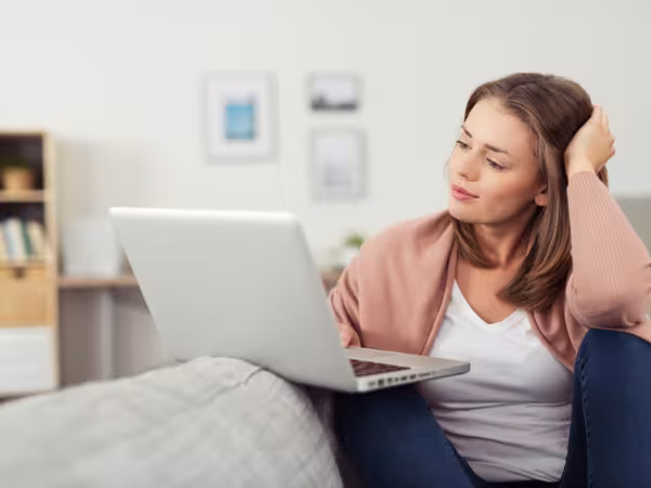 Frau surft auf der Couch im Internet 