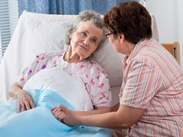 Eine Pflegerin am Bett einer Kranken