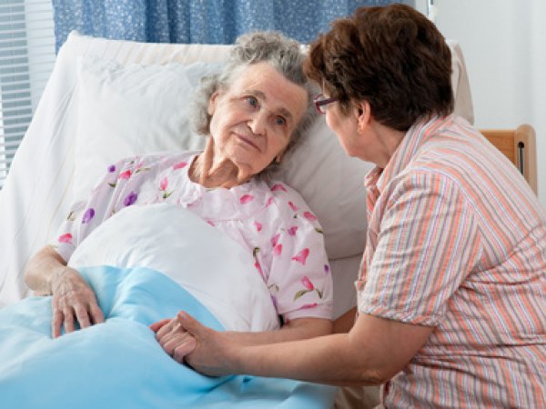 Eine Pflegerin am Bett einer Kranken