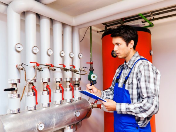 Monteur untersucht Heizungsanlage