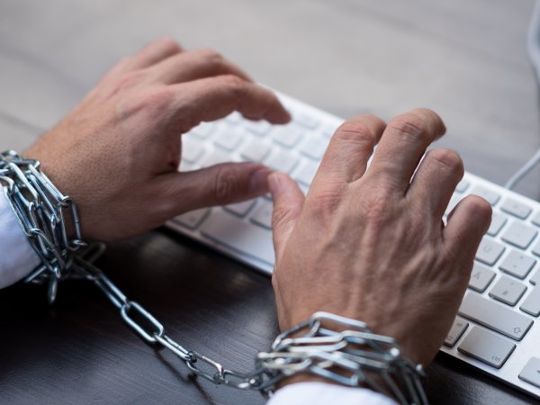 eingekettete Hände an Tastatur