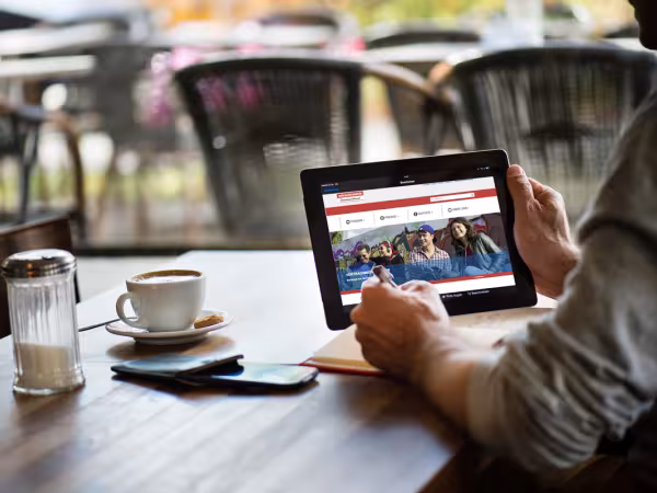 Mann betrachtet neue Webseite des vzbv auf Tablet