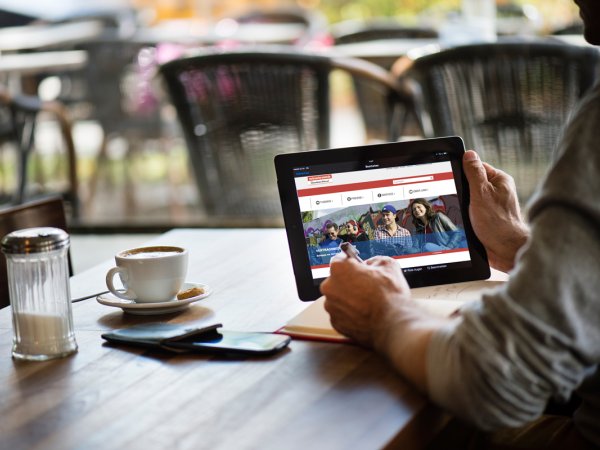 Mann betrachtet neue Webseite des vzbv auf Tablet
