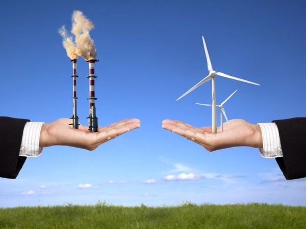 In einer Hand befindet sich ein Kohlekraftwerk, in der anderen ein Windpark 